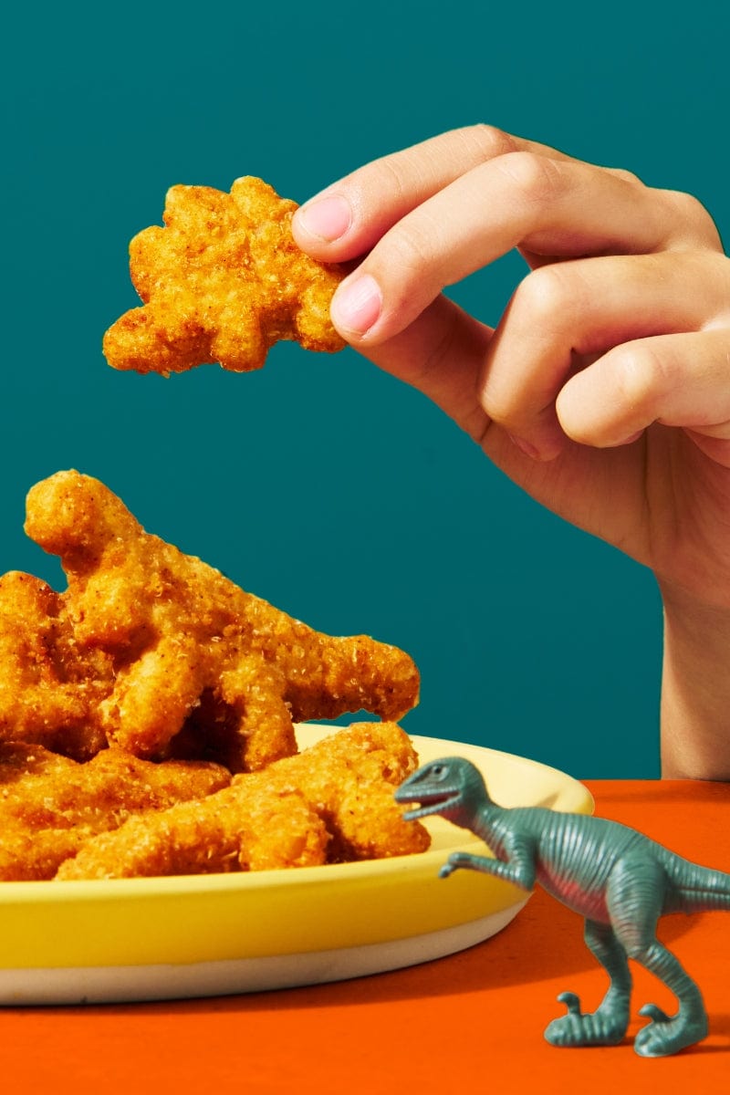 Kid playing with dino nuggets